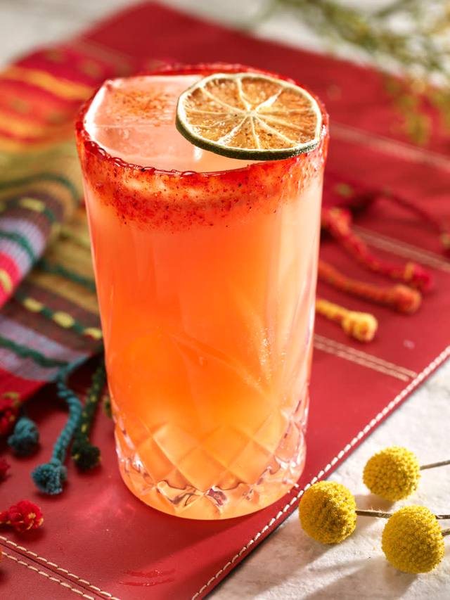 Chili salt rimmed highball of paloma with a dehydrated lime wheel