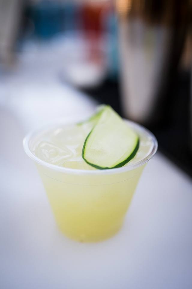 Chilled cucumber cooler in a clear cup garnished with a folded cucumber ribbon