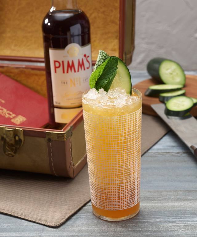 Tall Pimm's cup over crushed ice garnished with cucumber and mint