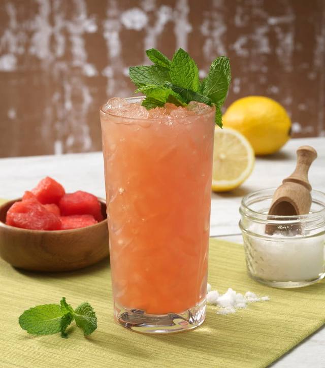 Tall watermelon mint cooler over crushed ice with a mint bouquet garnish
