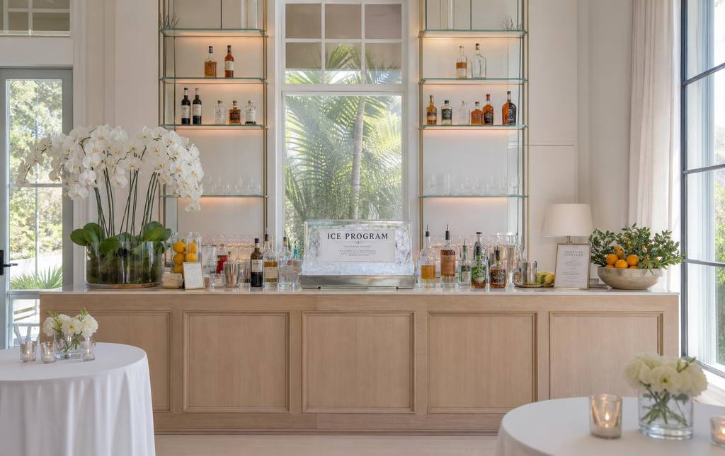 Styled private event bar with orchids, fresh citrus, and polished glassware