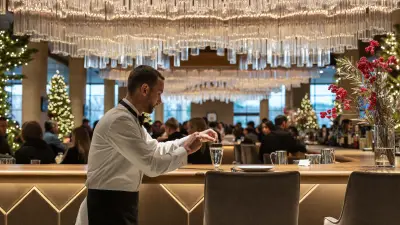 Bartender finishing a garnished cocktail at an elegant holiday party bar