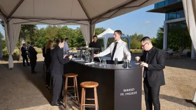 Hosted bar station at a corporate outdoor offsite with staff serving guests