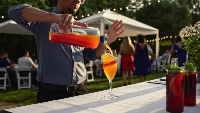 Bartender pouring a bright non-alcoholic cooler at an outdoor graduation party