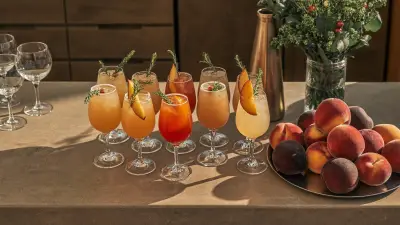Peach and stone fruit cocktails garnished on a wedding bar in late summer light