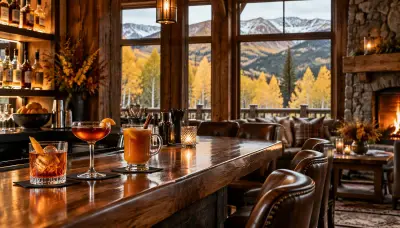 Bar set up inside a timber mountain lodge in Breckenridge with warm cocktails and golden aspens beyond the windows