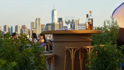 Compact bar setup on a city patio with cocktails and greenery